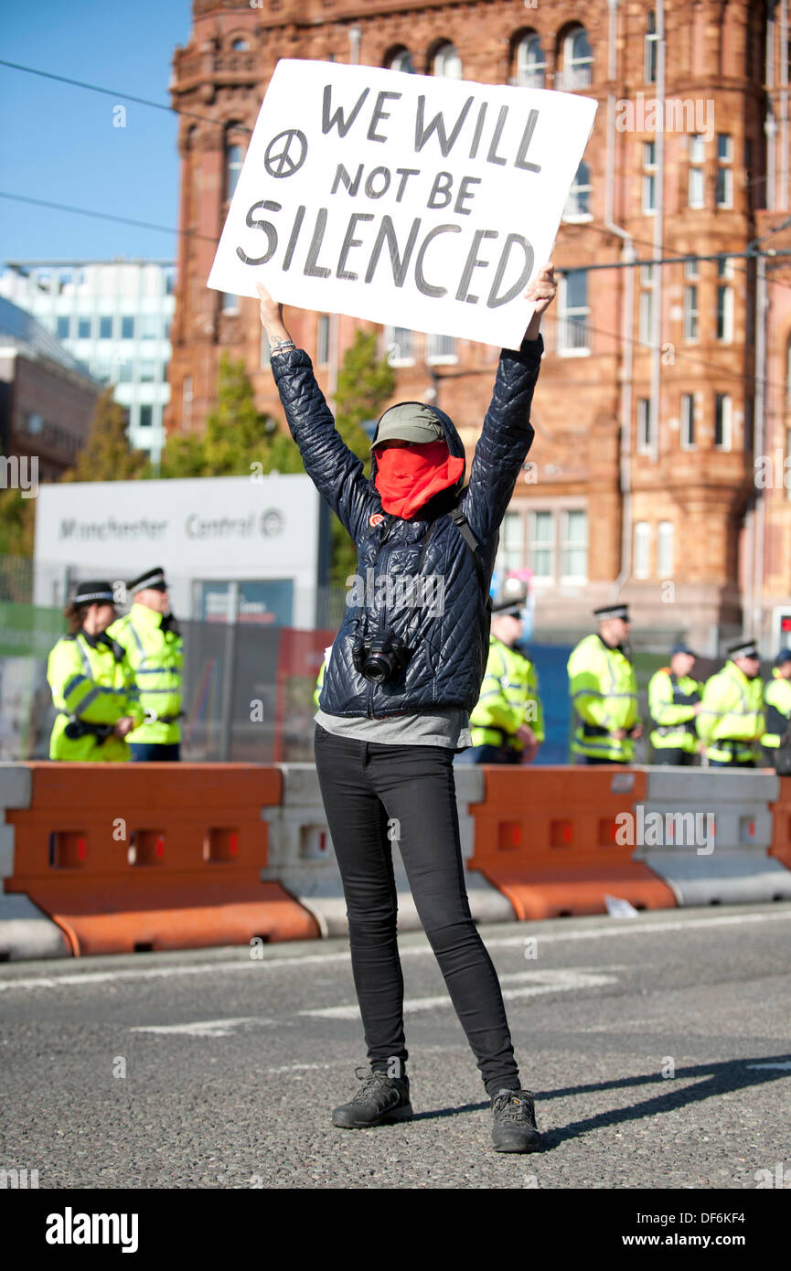 Manchester, UK. 29. September 2013. Eine maskierte Frau ein Schild mit der Aufschrift "Wir werden nicht zum Schweigen gebracht werden" hochhalten, während eine Nord-West TUC organisiert März und Rallye National Health Service (NHS) Arbeitsplätze und Dienstleistungen von Kürzungen und Privatisierungen verteidigen wollte. Der März fällt mit der konservativen Partei Konferenz 2013 in der Stadt statt. Bildnachweis: Russell Hart/Alamy Live-Nachrichten. Stockfoto