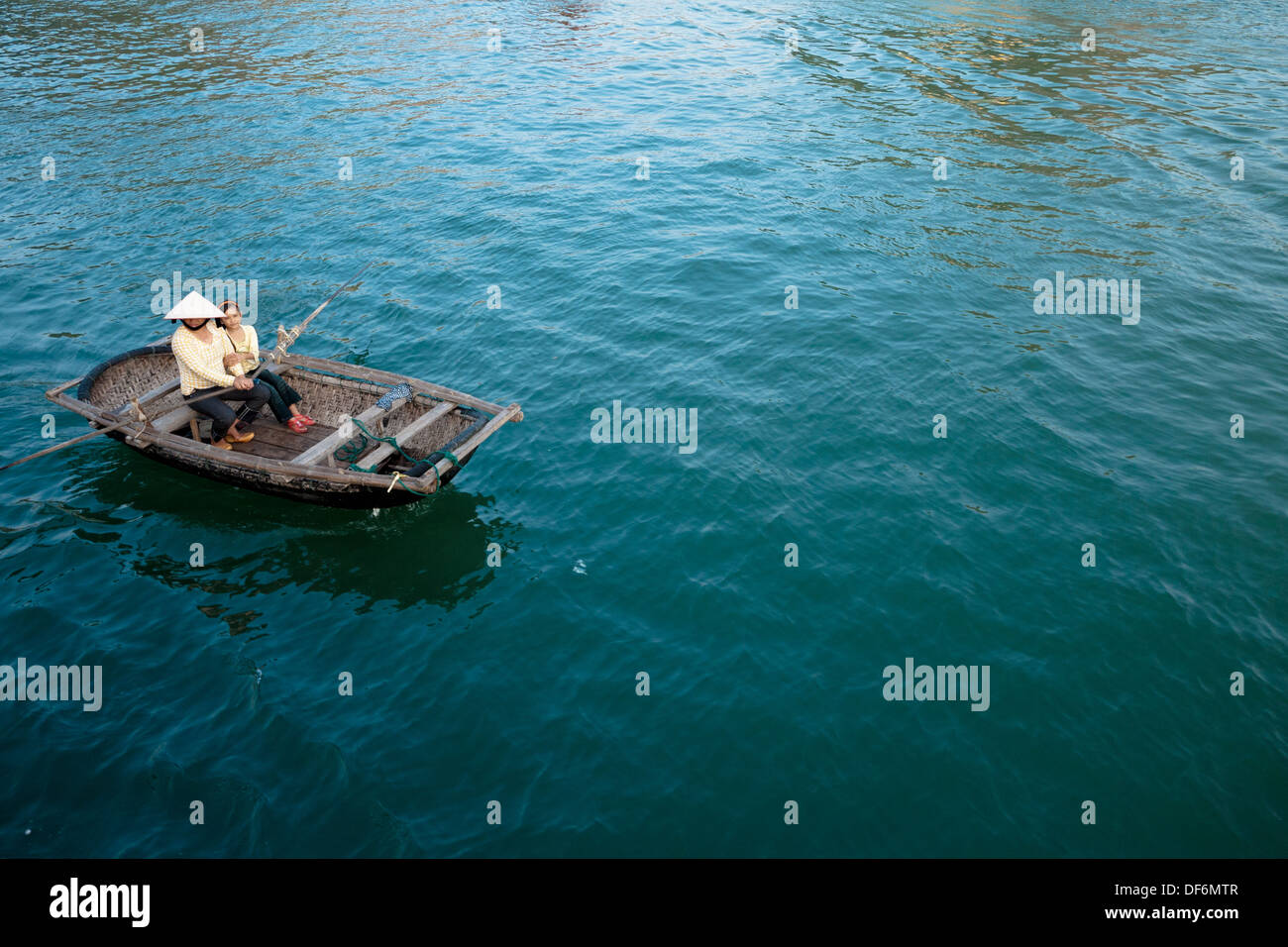 Eine Vietnamesin und ein vietnamesisches Mädchen in einem Ruderboot auf Lan-Ha-Bucht in der Nähe von Cat Ba Town in Halong Bucht, Vietnam. Stockfoto