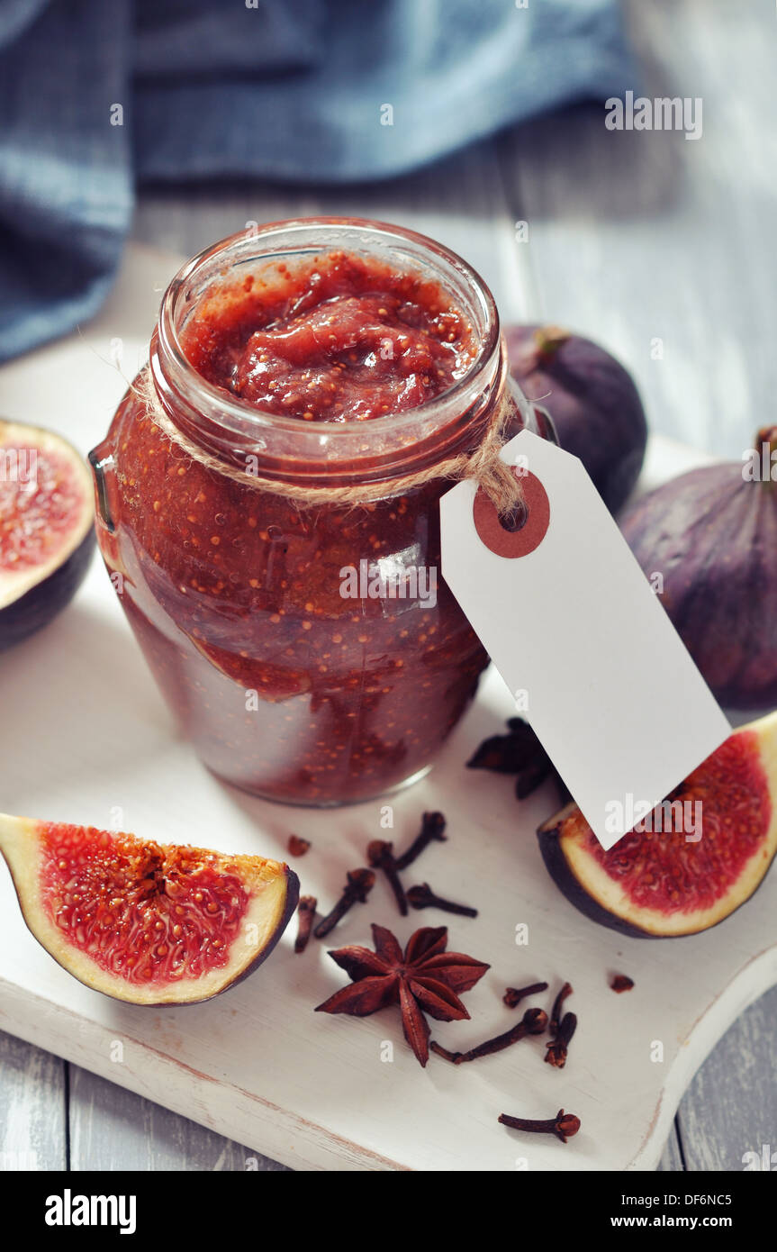 Abb. Marmelade in ein Glas mit frischen Feigen auf hölzernen Hintergrund Stockfoto