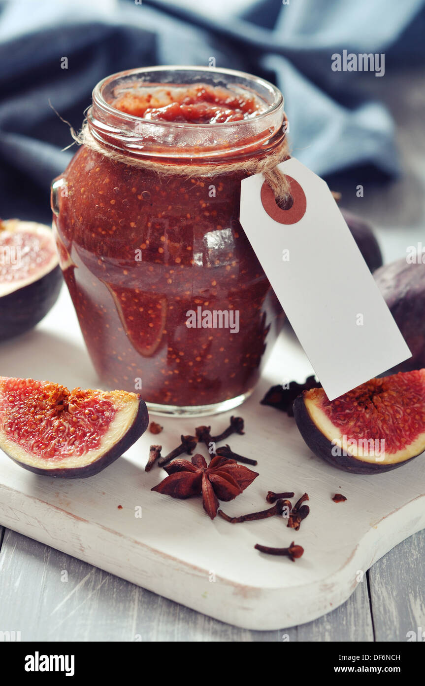 Abb. Marmelade in ein Glas mit frischen Feigen auf hölzernen Hintergrund Stockfoto