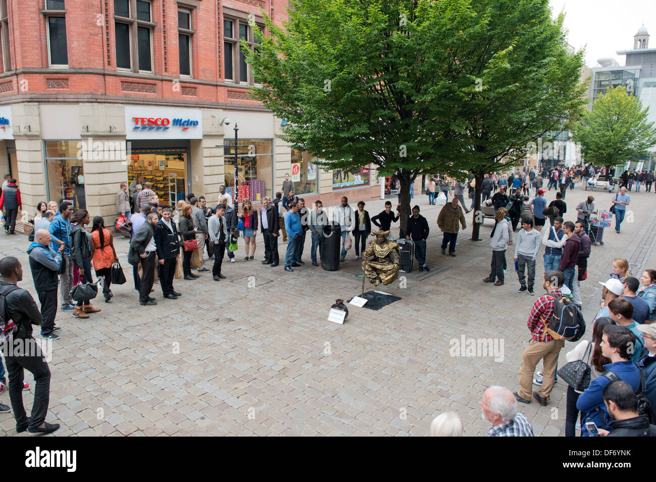 Ein schweben, die Streetart-Künstler an der Market Street im Stadtzentrum von Manchester, führt beobachtet von Passanten. Stockfoto
