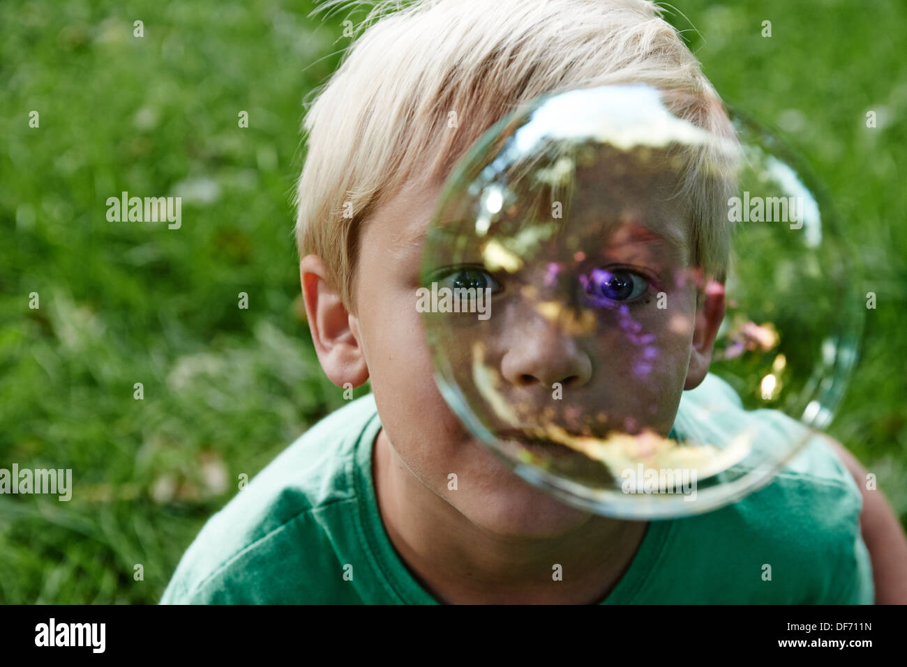 Kind blonde junge bläst und dabei Luftblasen im freien Stockfoto