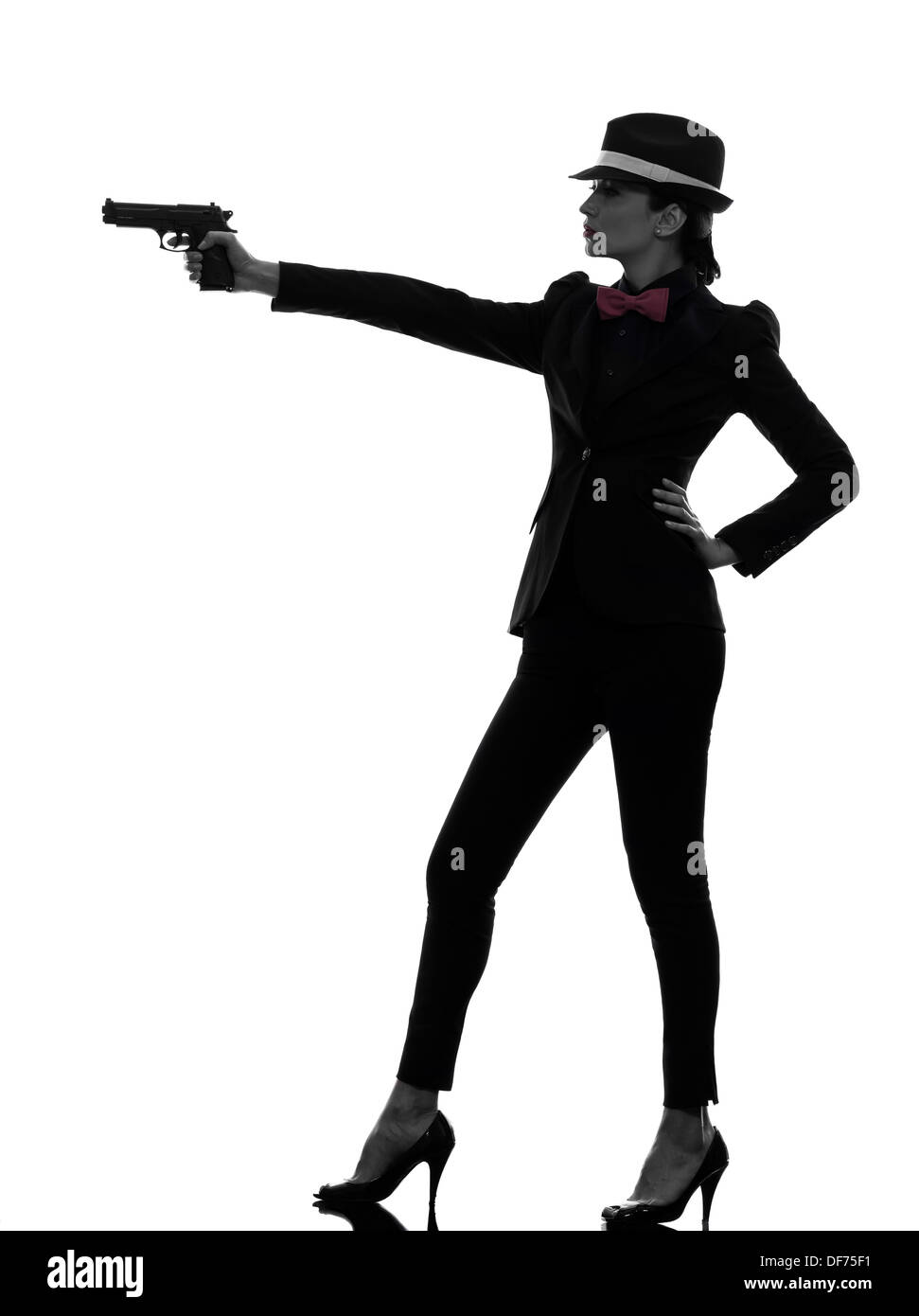 eine stilvolle Frau im Anzug mit Pistole in der Silhouette auf weißem Hintergrund Stockfoto