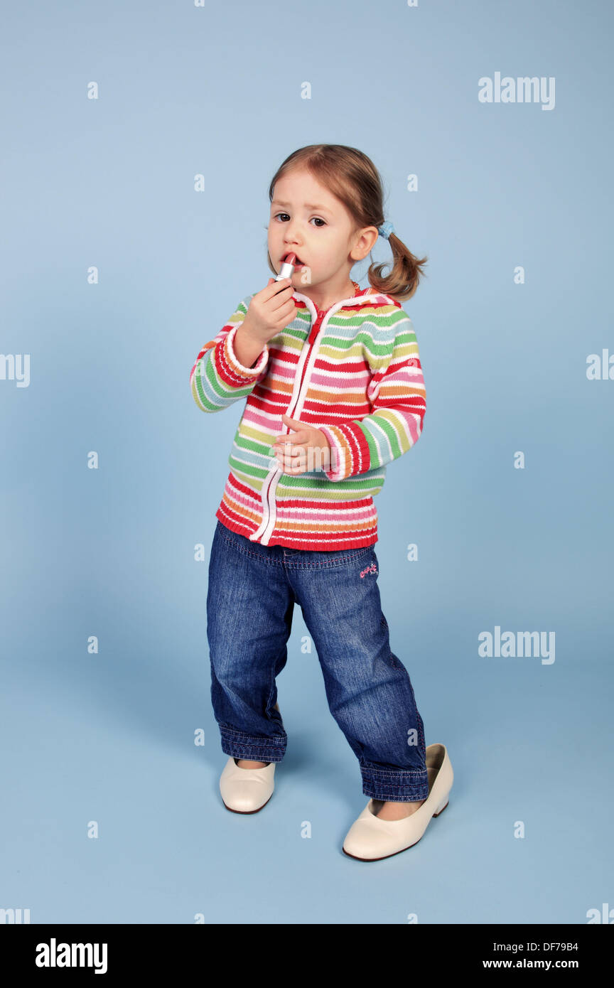 Kleinkind, Mädchen, tragen, Kleidschuhe anziehen Lippenstift, blauer  Hintergrund, Studio, Schweiz aufgewachsen Stockfotografie - Alamy