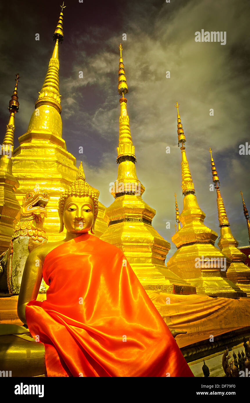 Die unterschiedlche sitzende Buddha-Statue in der Haltung der Meditation und Goldene Pagode. Stockfoto