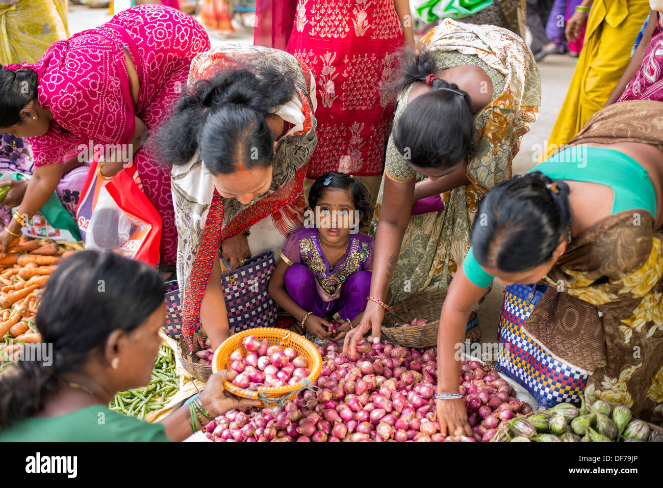 Indische Mädchen unter Müttern kaufen Gemüse aus einem Straßenmarkt. Puttaparthi, Andhra Pradesh, Indien Stockfoto