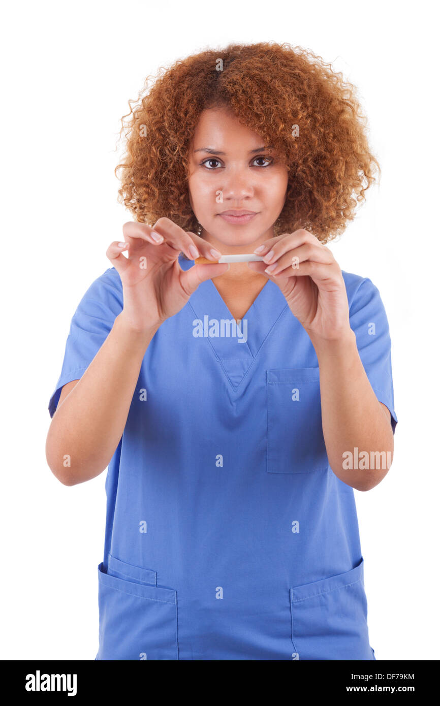 Afrikanische amerikanische Krankenschwester hält eine gebrochene Zigarette, isoliert auf weißem Hintergrund - schwarze Menschen Stockfoto