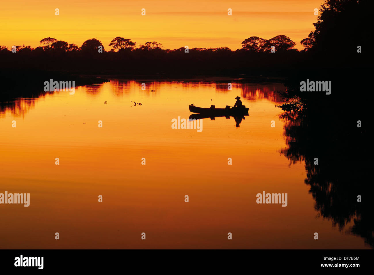 Brasilien, Pantanal: 05:30 am Rio Claro mit Silhouette eines Mannes in einem Fischerboot Stockfoto