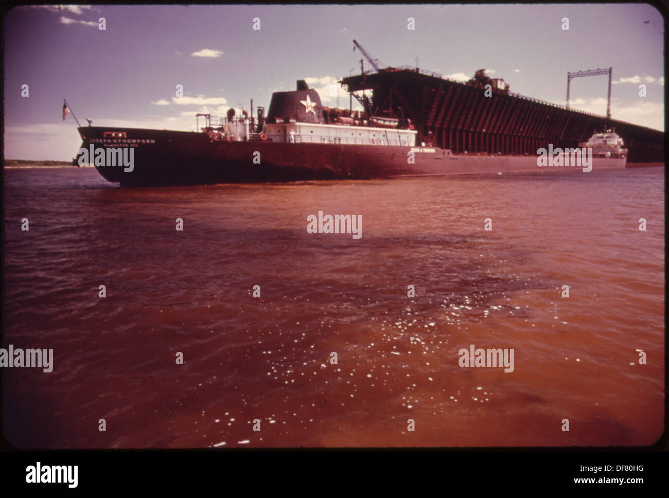 ROTEM LEHM VON DEN UFERN DES NEMADJI RIVER UND EISEN ERZ VERSCHÜTTEN IN BURLINGTON. NORTHERN RAILROAD LADERAMPEN... 551583 Stockfoto