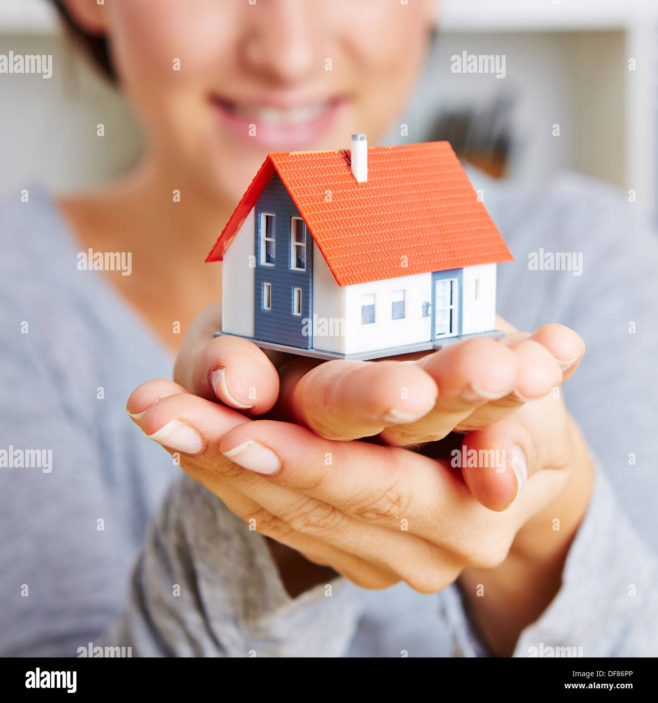 Zwei Hände einer Frau mit einem kleinen Haus Stockfoto Zwei Hände einer Frau mit einem kleinen Haus Stockfoto