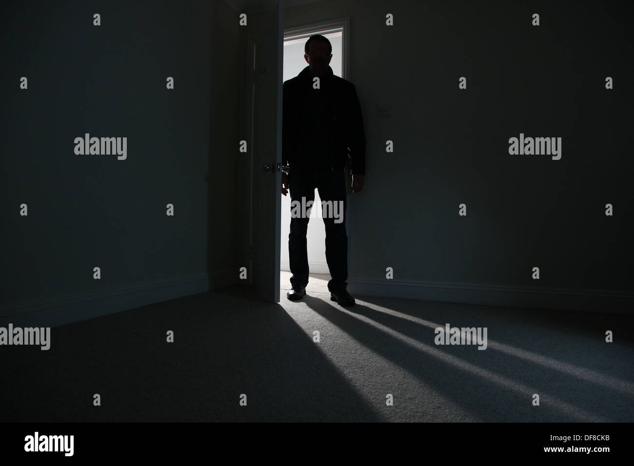 Silhouette eines männlichen Erwachsenen in einer offenen Tür stehe, in einen dunklen Raum. Modell veröffentlicht Stockfoto