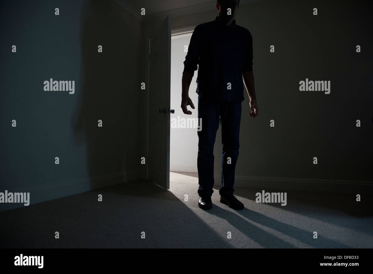 Silhouette eines männlichen Erwachsenen in einer offenen Tür stehe, in einen dunklen Raum. Modell veröffentlicht Stockfoto