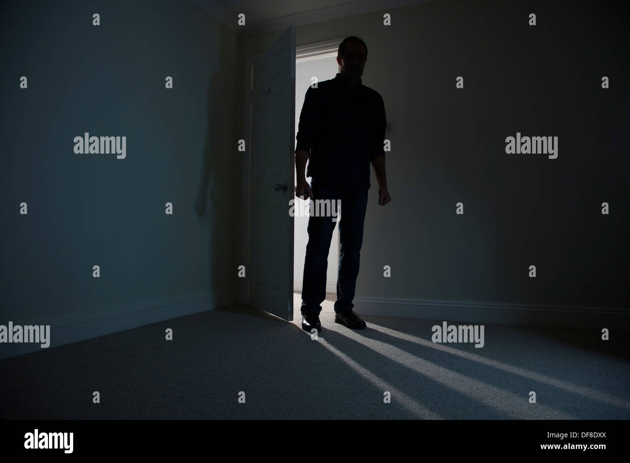 Silhouette eines männlichen Erwachsenen in einer offenen Tür stehe, in einen dunklen Raum. Modell veröffentlicht Stockfoto