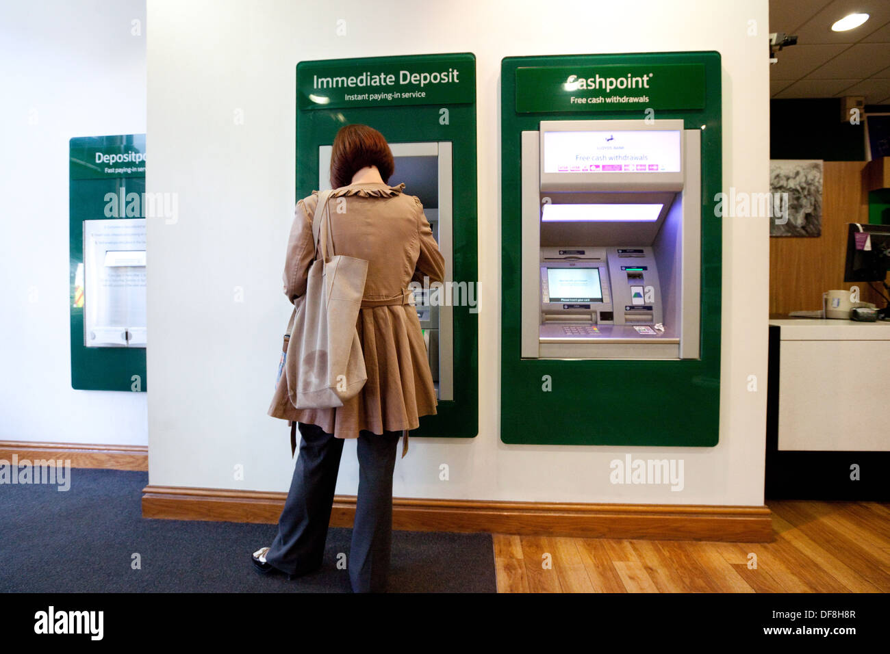 Ein Kunde mit dem neuen sofortige Anzahlung Facilty, Innenraum der Lloyds Bank, Konzept der modernen Technologie in Banken, UK Stockfoto