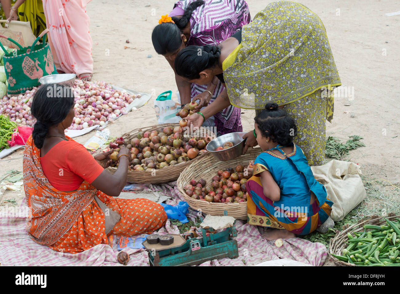 Indische Mädchen unter Müttern kaufen Gemüse aus einem Straßenmarkt. Puttaparthi, Andhra Pradesh, Indien Stockfoto