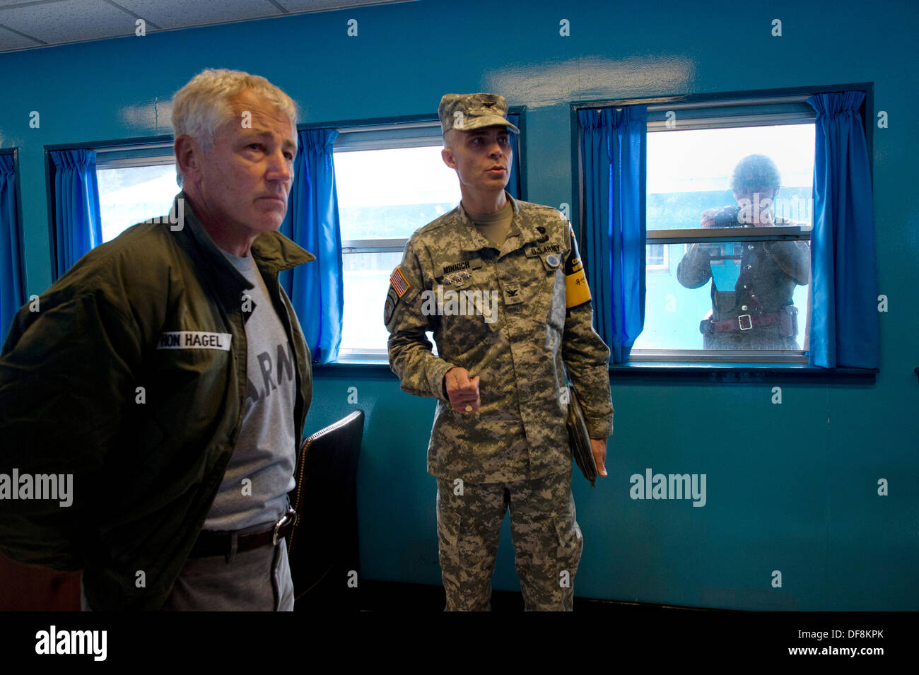 US-Verteidigungsminister Chuck Hagel erhält eine Einweisung in die Freedom House und die Konferenz Zeile wie ein nordkoreanischer Soldat Bilder durch ein Fenster 30. September 2013 in der entmilitarisierten Zone Panmunjom, Republik Korea nimmt. Stockfoto