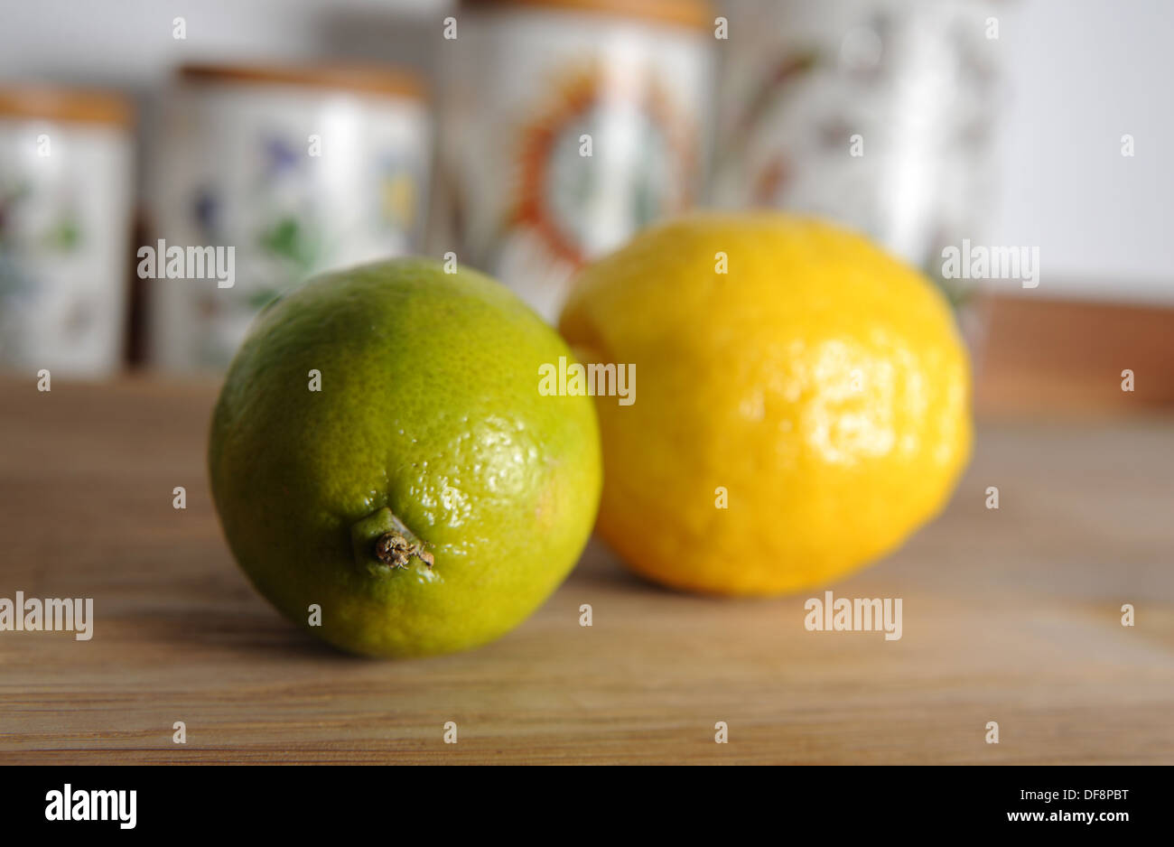 Zitrone und Limone auf Schneidbrett aus Holz Stockfoto