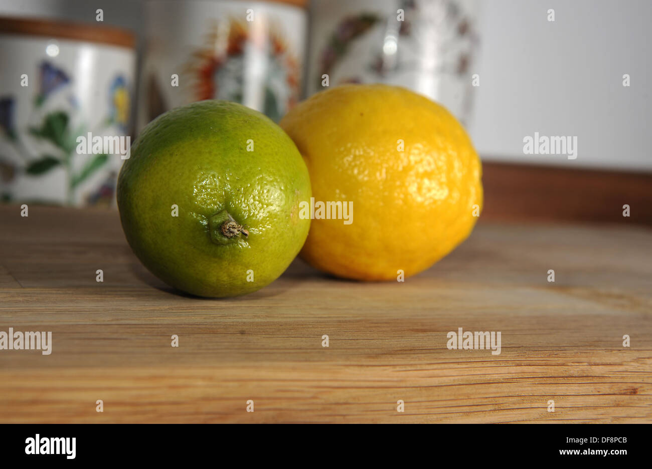 Zitrone und Limone auf Schneidbrett aus Holz Stockfoto