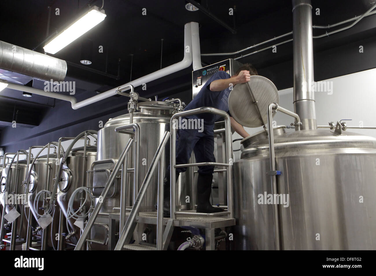 Master-Brewer Galaxy Brewing Co. Mikro-Brauerei sieht in einen Tank in Binghamton, New York Stockfoto