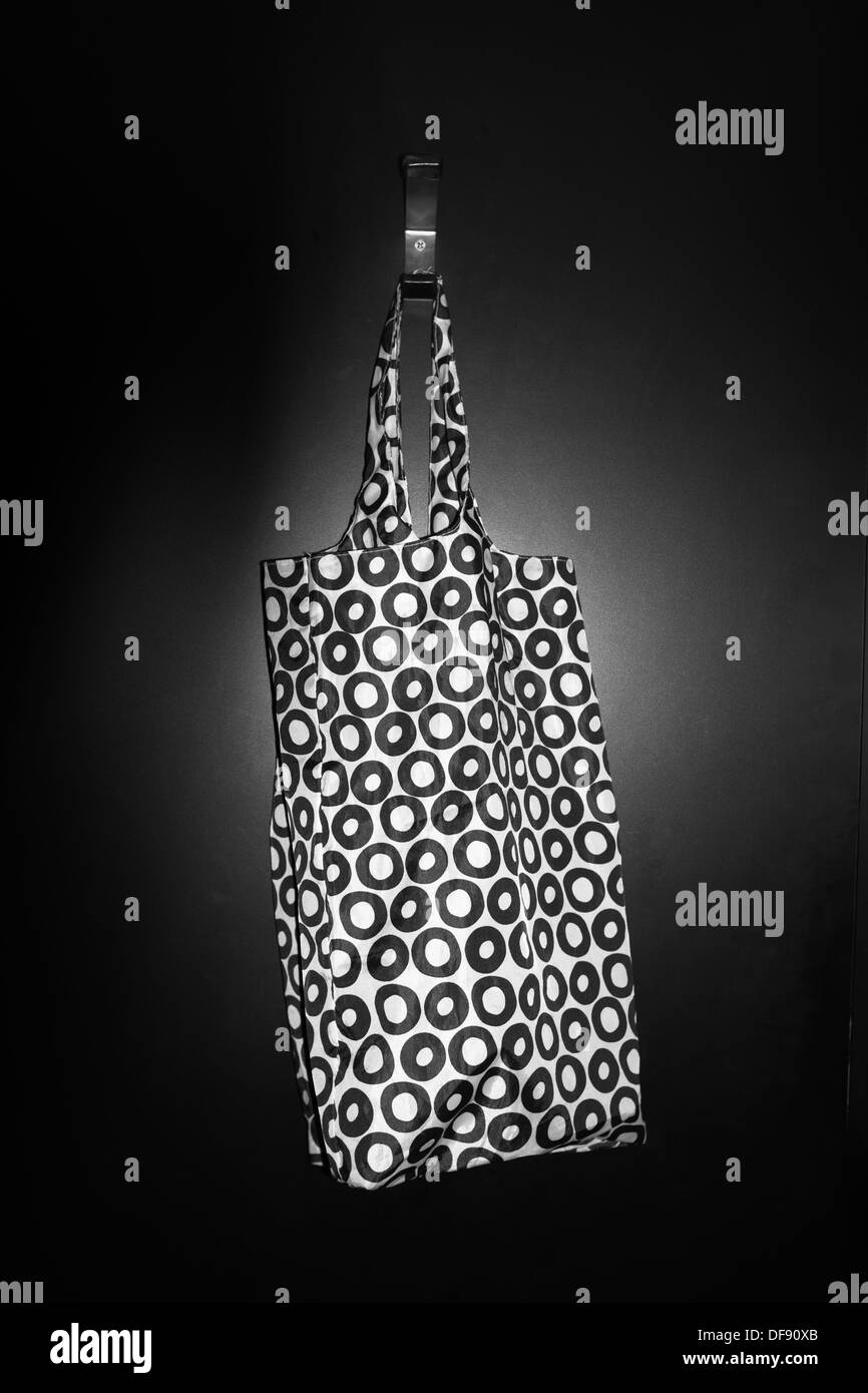 Wieder verwendbare Einkaufstasche mit schwarzen & weißer Kreis Design an eine Tür hängen. Stockfoto