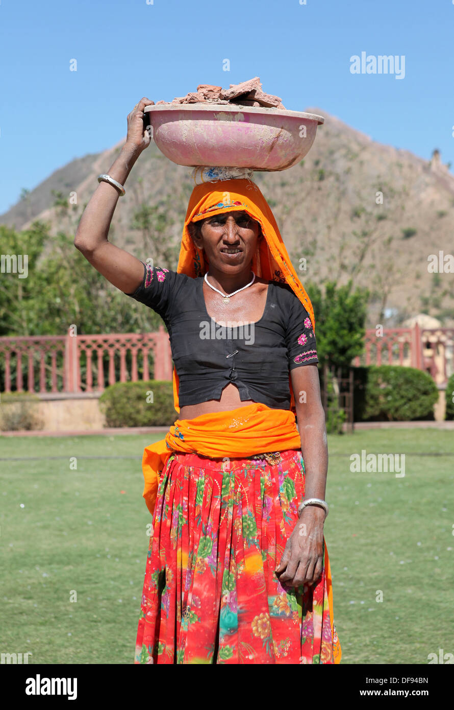 Frau, die eine große Schüssel gefüllt Schutt von einer Baustelle auf dem Kopf, Jaipur, Rajasthan, Indien, Stockfoto