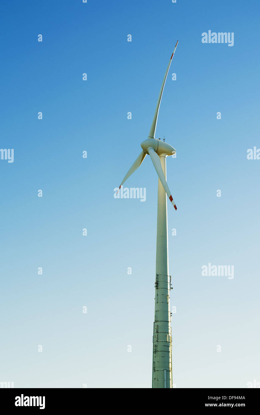 Ein Wind-Motor vor einem blauen Sommerhimmel. Vertikal Stockfoto