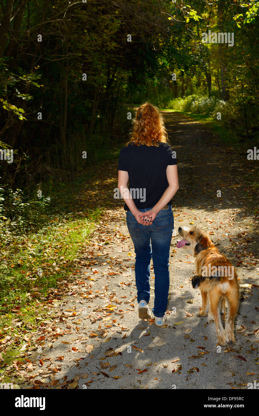Aufmerksamen Hund Leine mit jungen Frau zu Fuß auf einem Pfad in einem Wald von Toronto Stockfoto