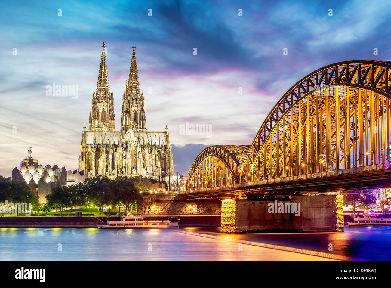 Beleuchteten Dom in Köln mit Brücke und Rhein bei Sonnenuntergang Stockfoto