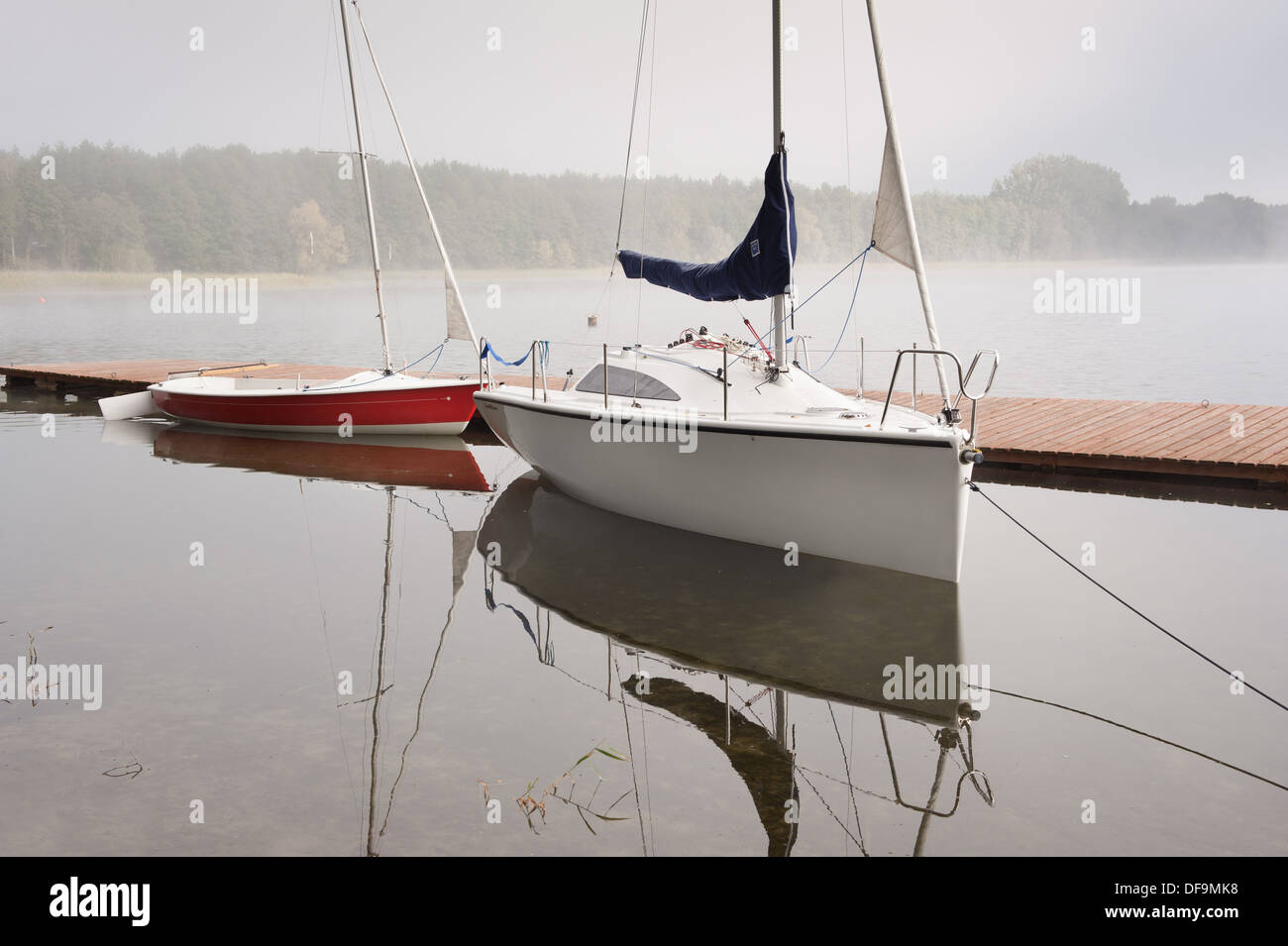 Zwei Boote im Nebel vor Anker Boardwalk am See Stockfoto