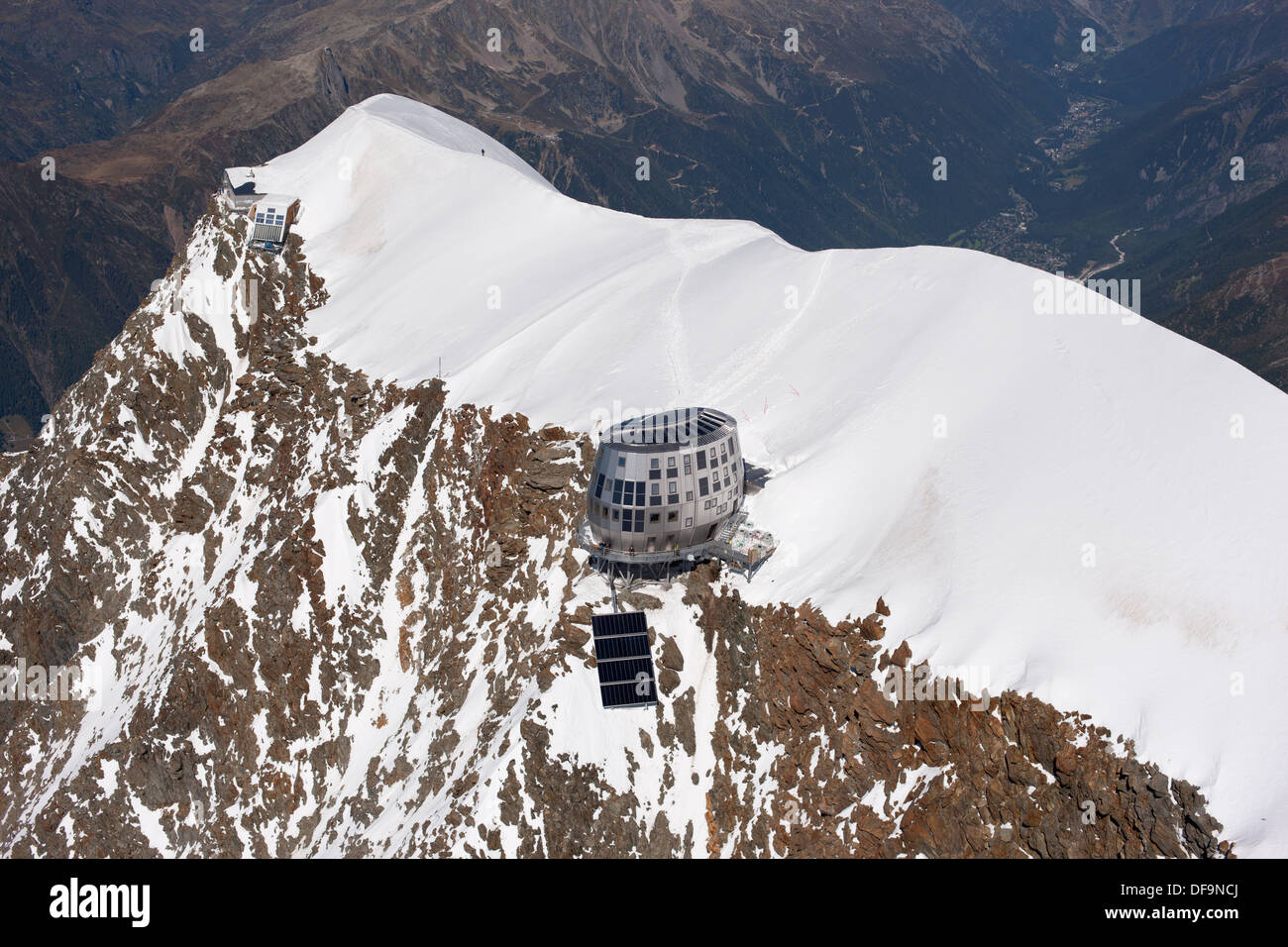 LUFTAUFNAHME. Aiguille du Goûter (Höhe: 3863m) mit der neuen Berghütte am Rand der Klippe. Saint-Gervais, Auvergne-Rhône-Alpes, Frankreich. Stockfoto