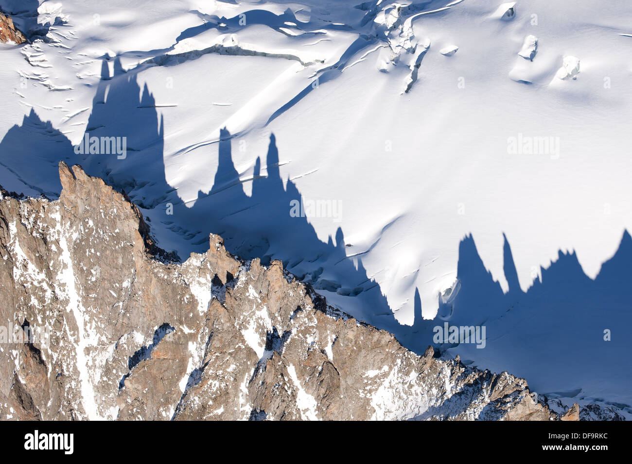 LUFTAUFNAHME. Granitfelsen werfen einen langen Schatten auf den Mont Mallet Gletscher. Les Périades Needles, Chamonix Mont-Blanc, Haute-Savoie, Frankreich. Stockfoto