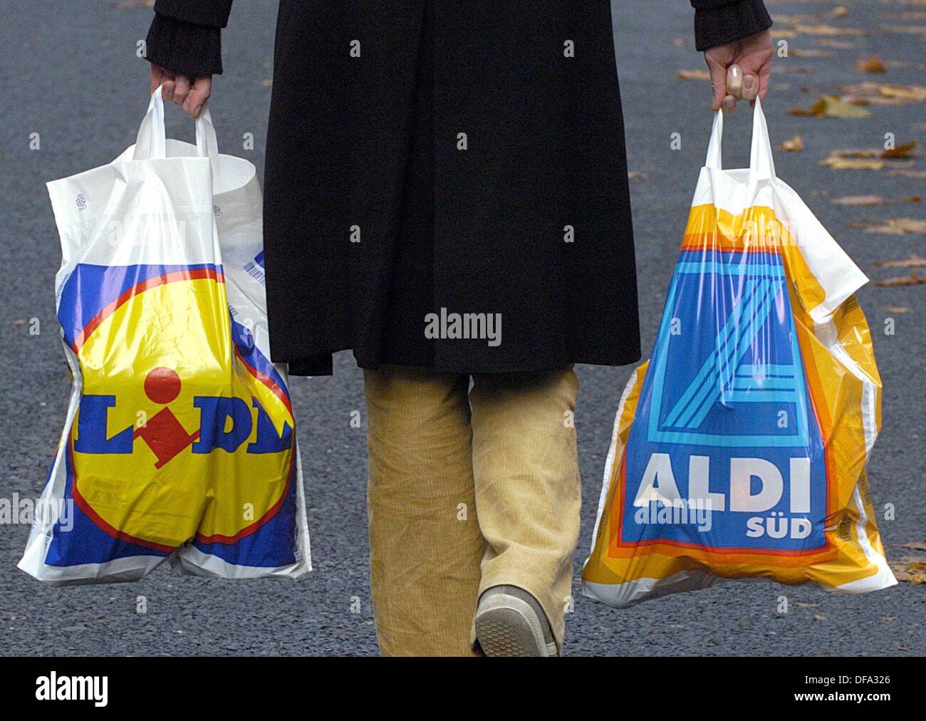 Eine Frau trägt eine Plastiktüte der Discounter "Lidl" und eines "Aldi" in Köln am 17. November 2003. Deutschlands zweitgrößte Discounter Lidl wird nicht mehr von der Industrie Nummer eins Aldi überschattet. Stockfoto