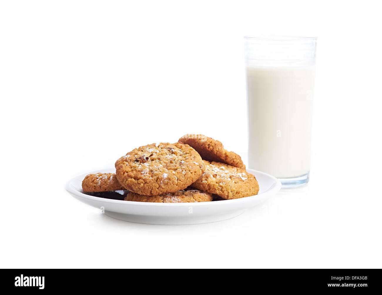 Ein Haufen von gemischten Cookies auf einem weißen Teller und Hintergrund mit einem Glas Milch. Stockfoto