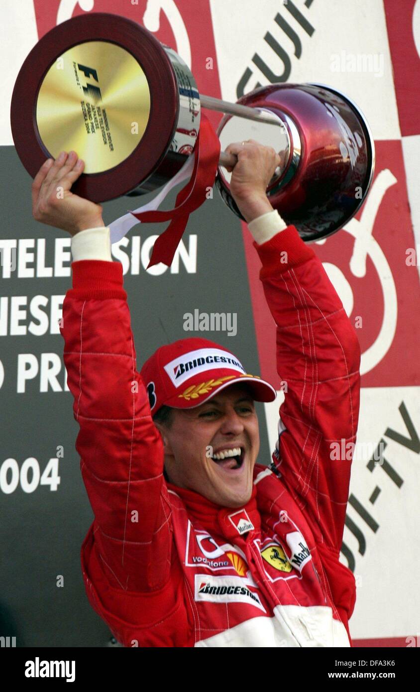 Deutsche Formel-1-Weltmeister Michael Schumacher hält seine Trophäe nach seinem Sieg beim Grand Prix von Japan am 10. Oktober 2004. Er wurde zum "Sportler des Jahrhunderts" gewählt. Stockfoto