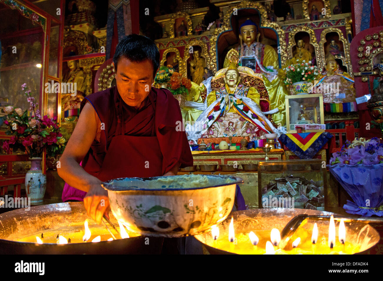 Buddhistischer Mönch Beleuchtung Yak Butterlampen, Drepung Kloster, Lhasa, Tibet Stockfoto