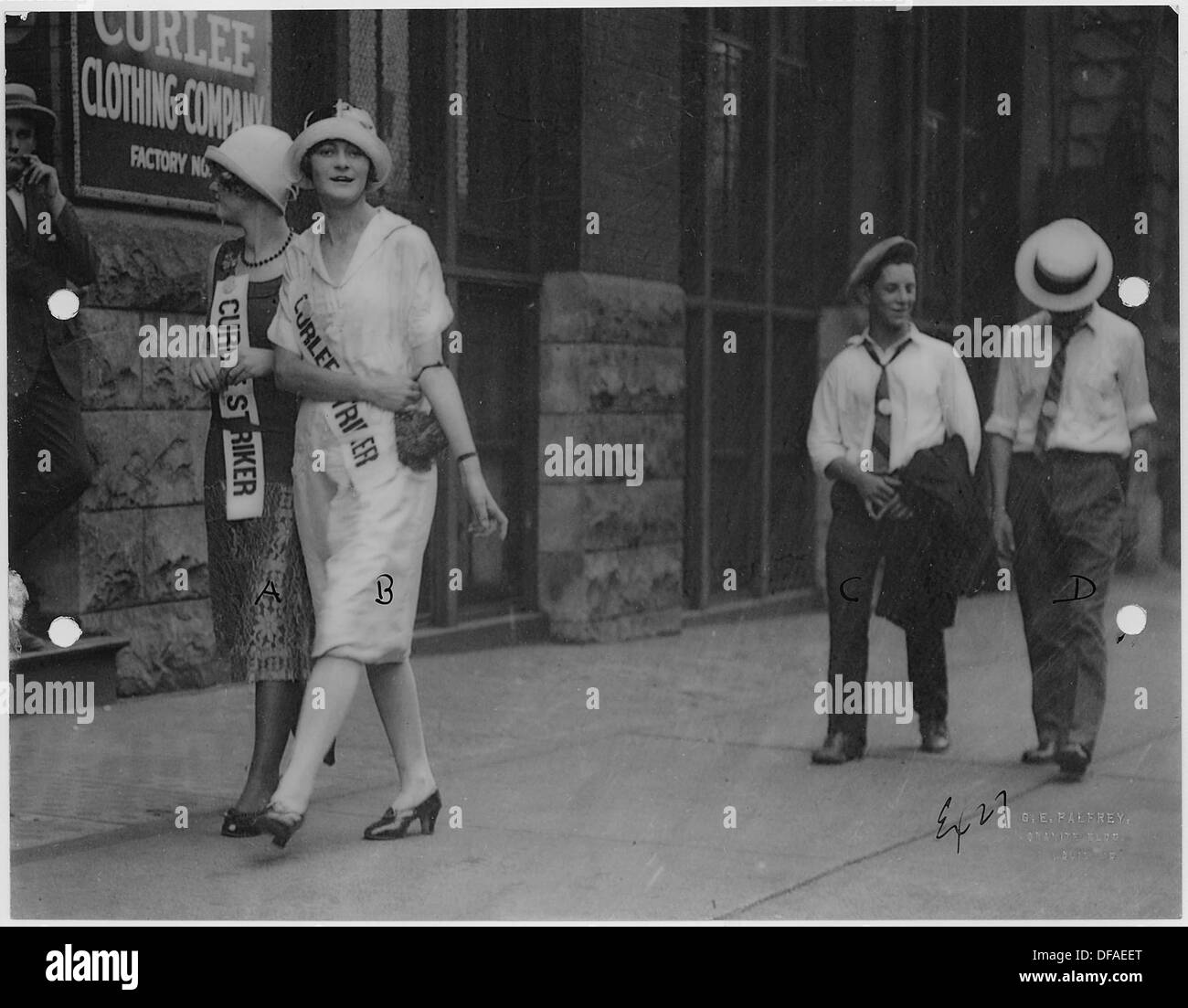 Frauen und ein paar Männer nehmen an einem Streik vor der Curlee Clothing Company in St. Louis Teil. Dieser Protest bezieht sich wahrscheinlich auf Arbeitnehmerrechte oder Arbeitsbedingungen in der Bekleidungsindustrie. Stockfoto