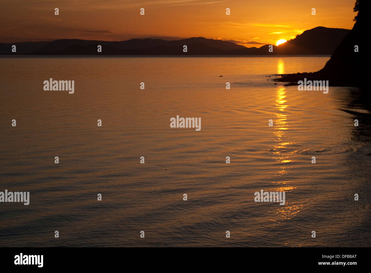 Sonnenuntergang hinter San Juan Inseln im Ozean reflektiert Stockfoto