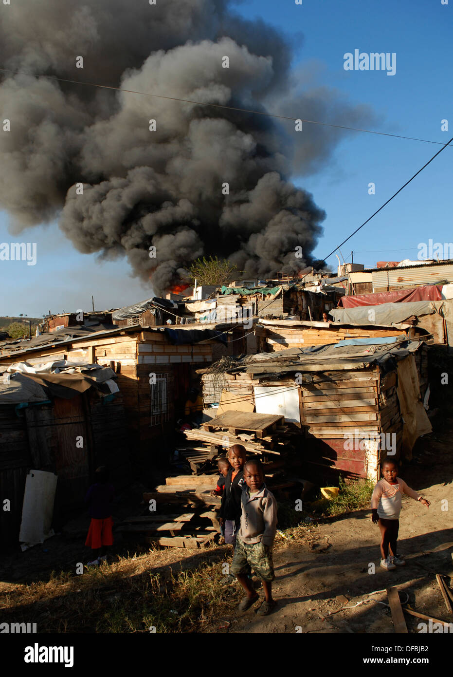 Kinder blicken auf eine Hütte Feuer wütet Kontrollen in Kennedy Road informellen Siedlung in Durban 14. Juli 2008 © Rogan Ward 2008 Stockfoto