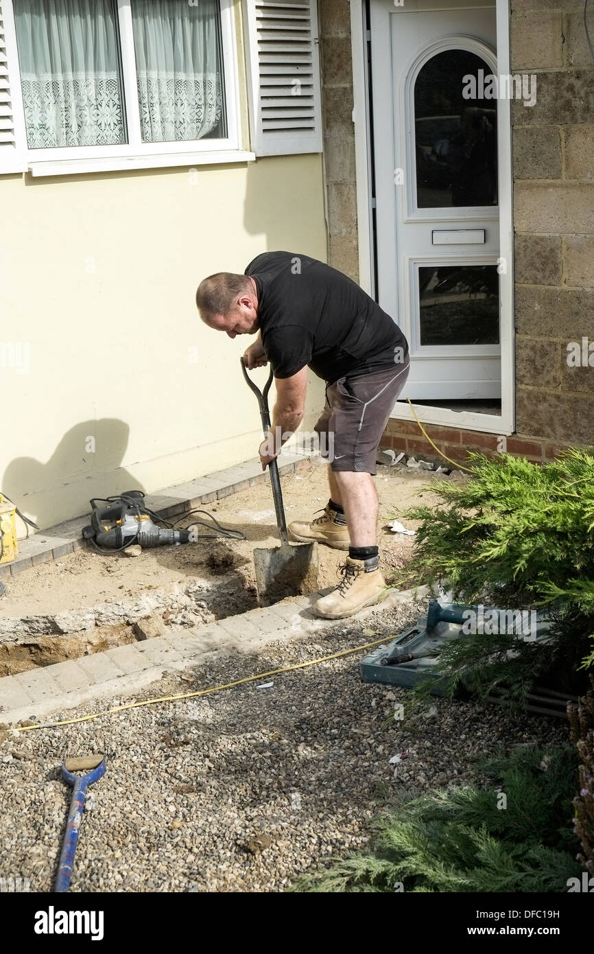 Ein Baumeister einen Graben in Vorbereitung für die Verlegung neuer Abwasserleitungen. Stockfoto