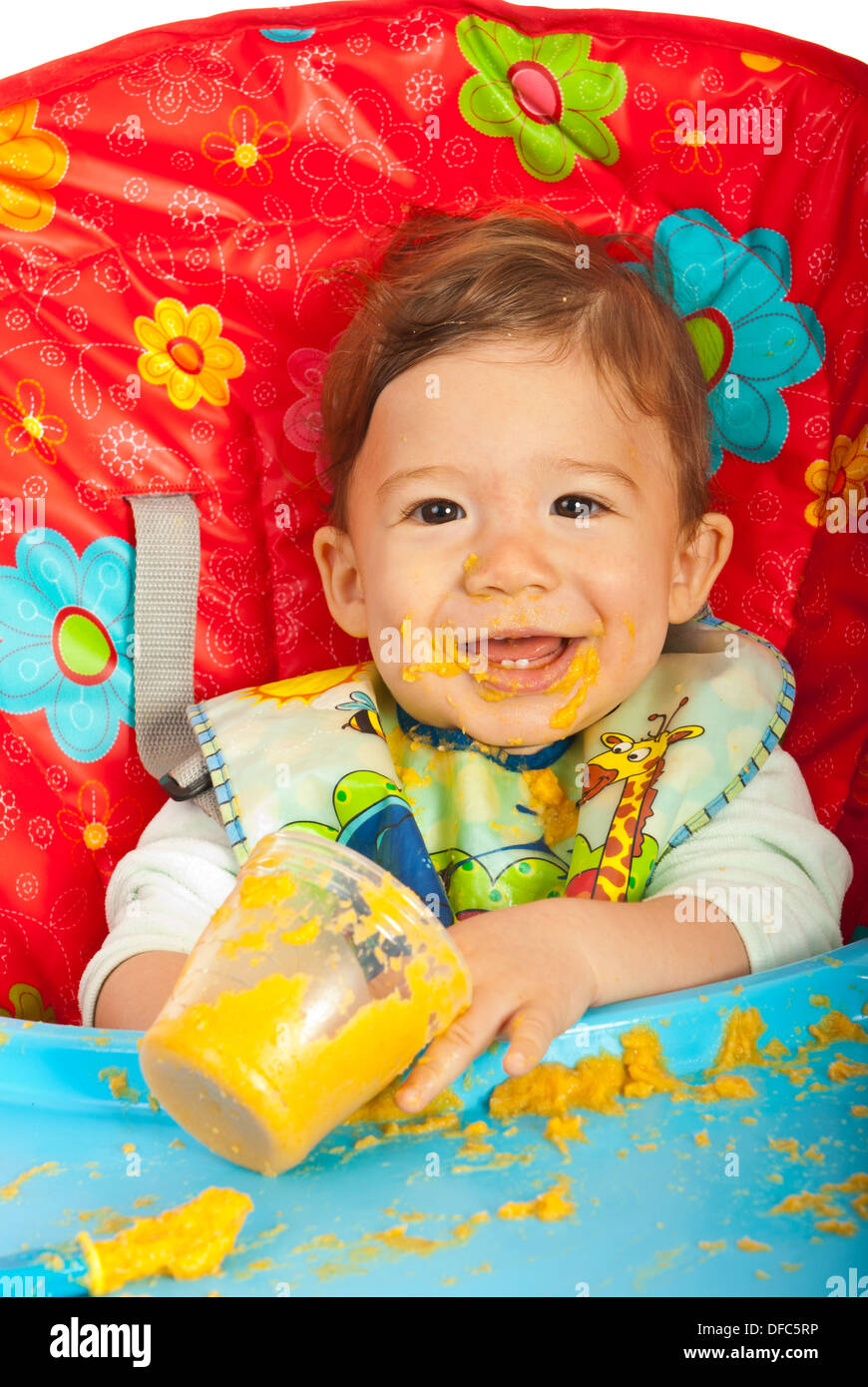 Glückliches Baby im Stuhl sitzen und Essen Gemüse-Püree Stockfoto