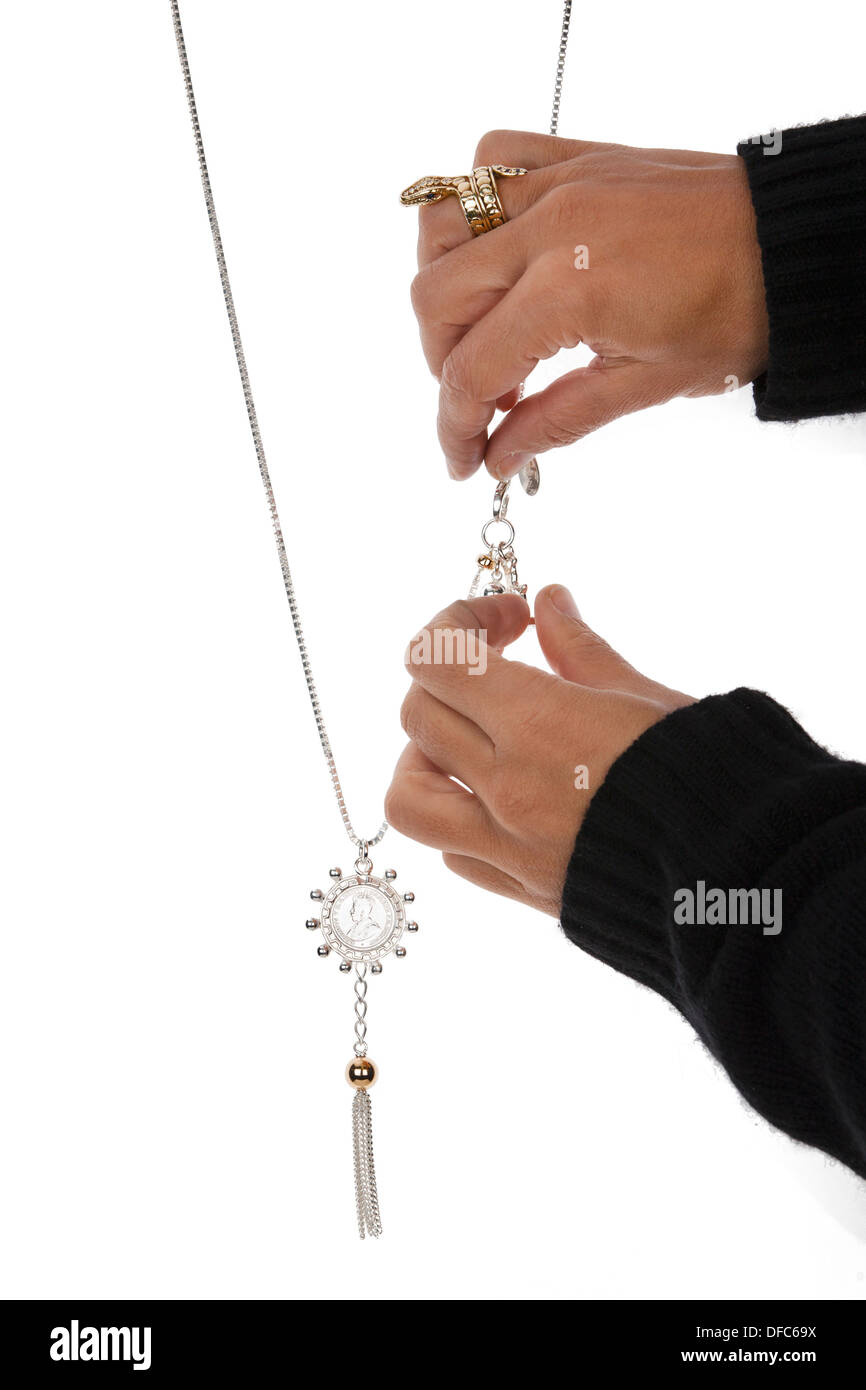 Womans hand Positionierung Schmuck Kette vor weißem Hintergrund. Stockfoto