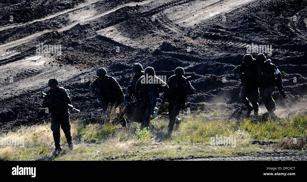 Soldaten tragen einen verletzten Kameraden während der Bundeswehr-Übung "Landoperationen" in Bergen, Deutschland, 2. Oktober 2013. Die Bundeswehr-Übung "Landoperationen" statt findet vom 30. September bis zum 10. Oktober 2013 um Truppenübungsplätze Munster und Bergen. Foto: Peter Steffen Stockfoto