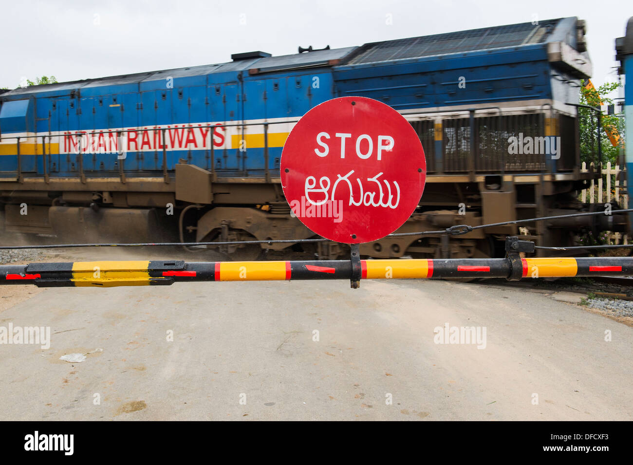 Stoppschild auf einer indischen Bahnübergang mit einem Zug vorbei. Andhra Pradesh, Indien Stockfoto