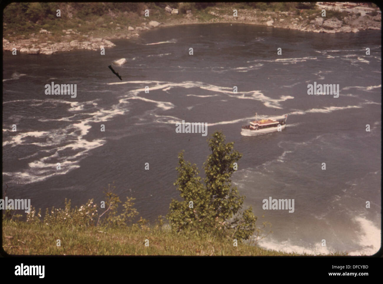 Die Maid-of-the-Mist, ein dieselbetriebenes Sightseeing-Boot, fährt auf dem Niagara River direkt unter den Wasserfällen und bietet Touristen einen Blick auf das berühmte Wahrzeichen und die umliegenden Wasserschaummuster. Stockfoto