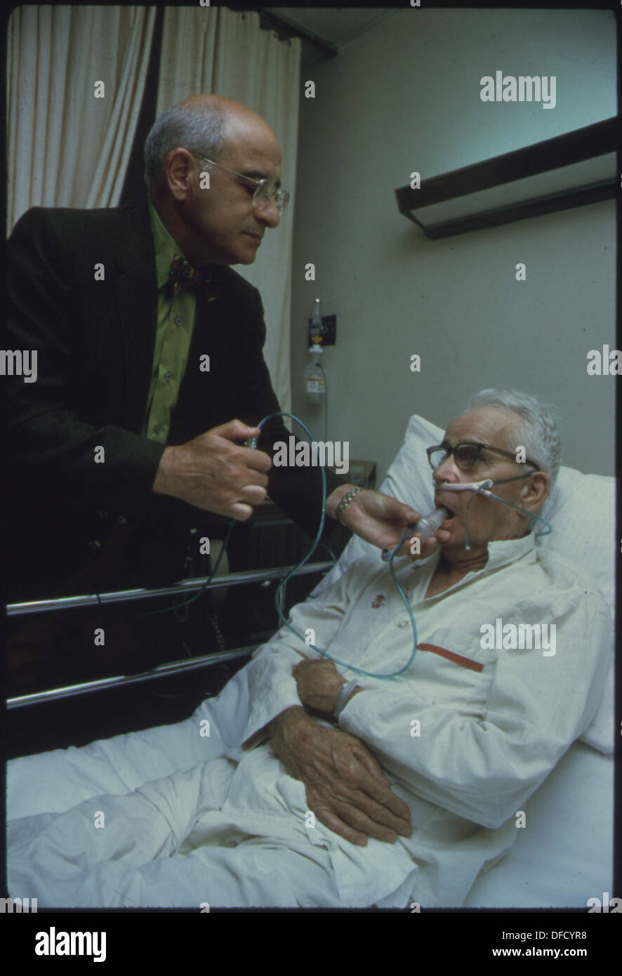 Ein Arzt betreut einen Patienten mit roter Lunge, einer Erkrankung, die durch das Einatmen von Staub in Eisenminen verursacht wird. Dieses Bild aus der Documerica-1-Ausstellung zeigt die Gefahren, denen Bergleute ausgesetzt sind. Stockfoto