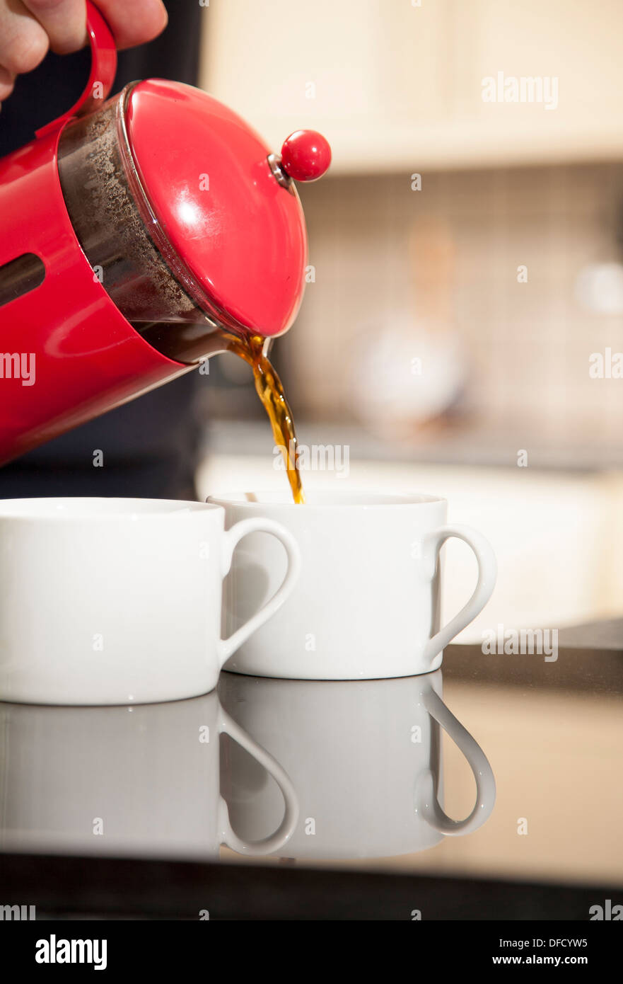 Frisch gemahlener Kaffee gießen in einer roten Getränketablett Stockfoto
