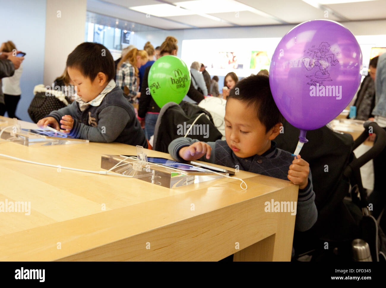 Apple Store Interior; Kinder spielen mit iPads im Apple Store, Norwich, Norfolk UK Stockfoto