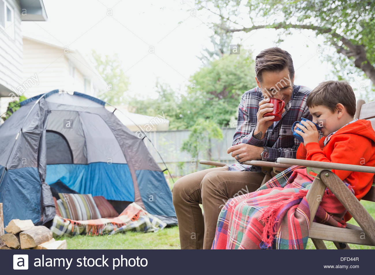 Vater und Sohn, die heißen Schokolade zu trinken, beim camping im Garten Stockfoto