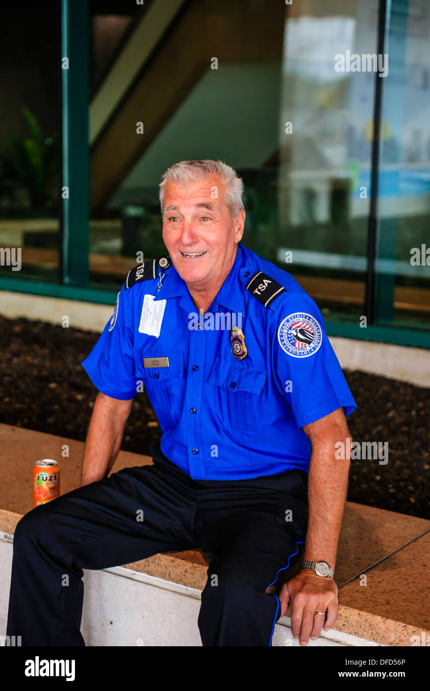 Ein TSA-Agent am Flughafen Sarasota nimmt sich eine Auszeit von seinen Aufgaben und genießt ein Colling alkoholfreies Getränk Stockfoto