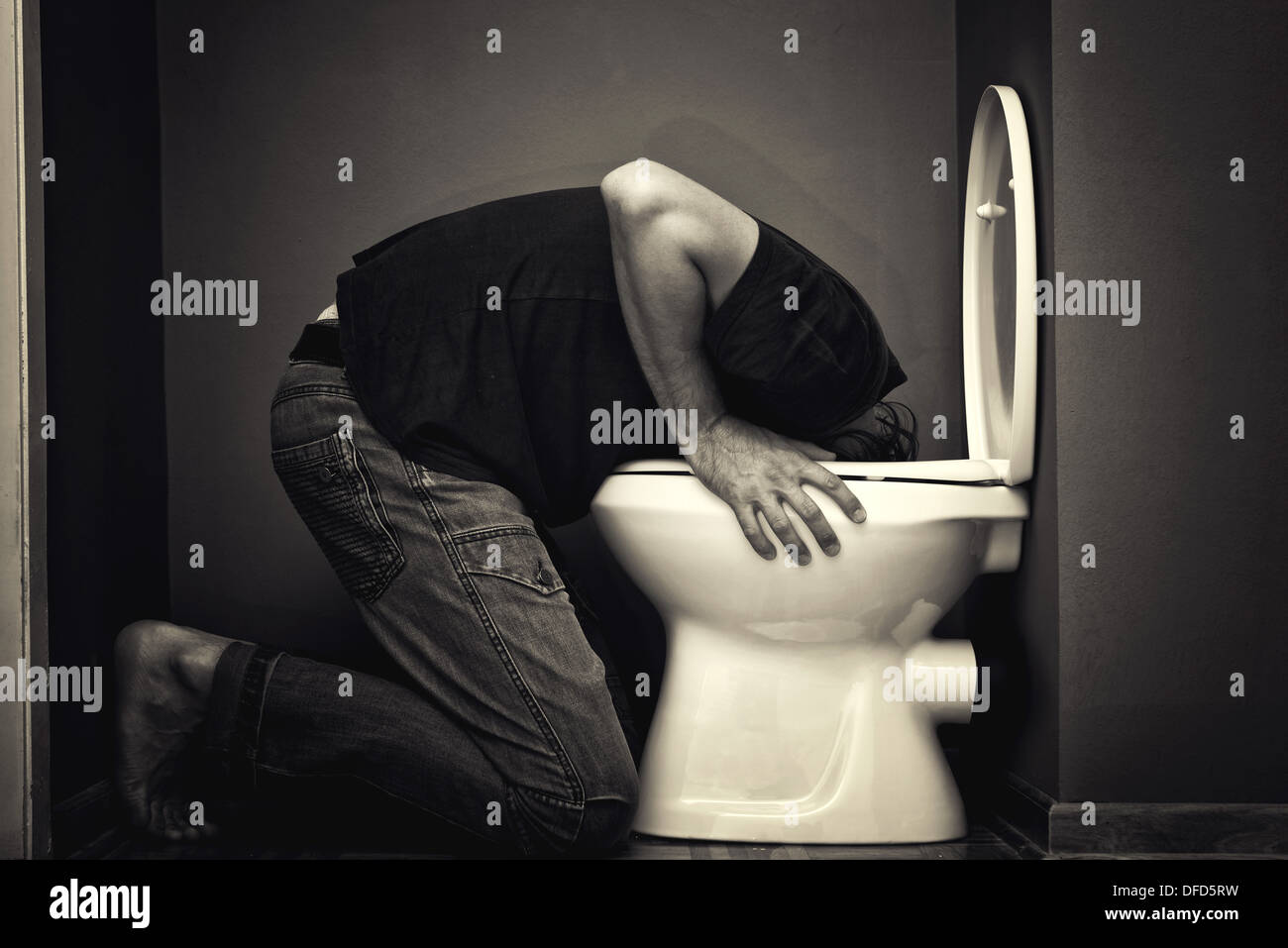 Mann in WC-Schüssel Erbrechen Stockfoto